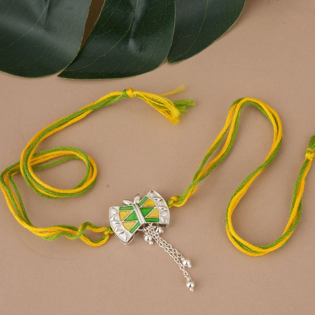 Damru 92.5 sterling silver rakhi with green and yellow enamel Damru 92.5 sterling silver rakhi with green and yellow enamel