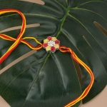 Rangoli 92.5 sterling silver rakhi with red and yellow enamel